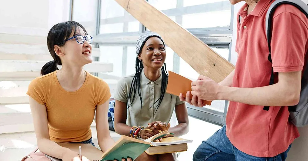 Students talking together while holding books
